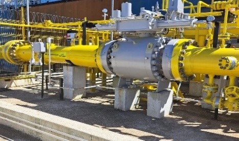 Tubulação industrial amarela com válvulas e atuadores em planta de gás